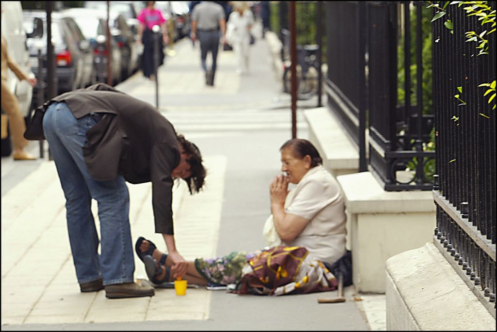 パリの道端で物乞いをする女性に寄付するキアヌ〔PHOTO〕Getty Images